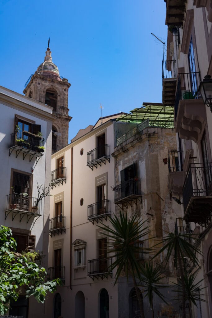 old heritage buildings with a church steeple behind them in Palermo, Sicily