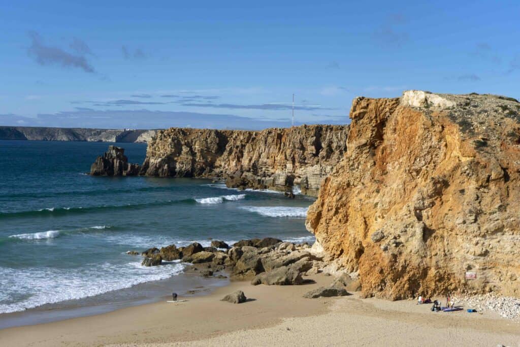 rocky cliffs, sand, and waves at Praia do Tonel in Algarve in fall.