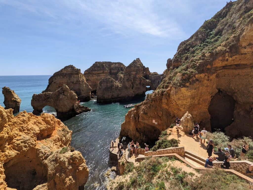 Golden limestone sea stacks, arches, and turquoise coves at Ponta da Piedade near Lagos, viewed from the cliffside walking trail.