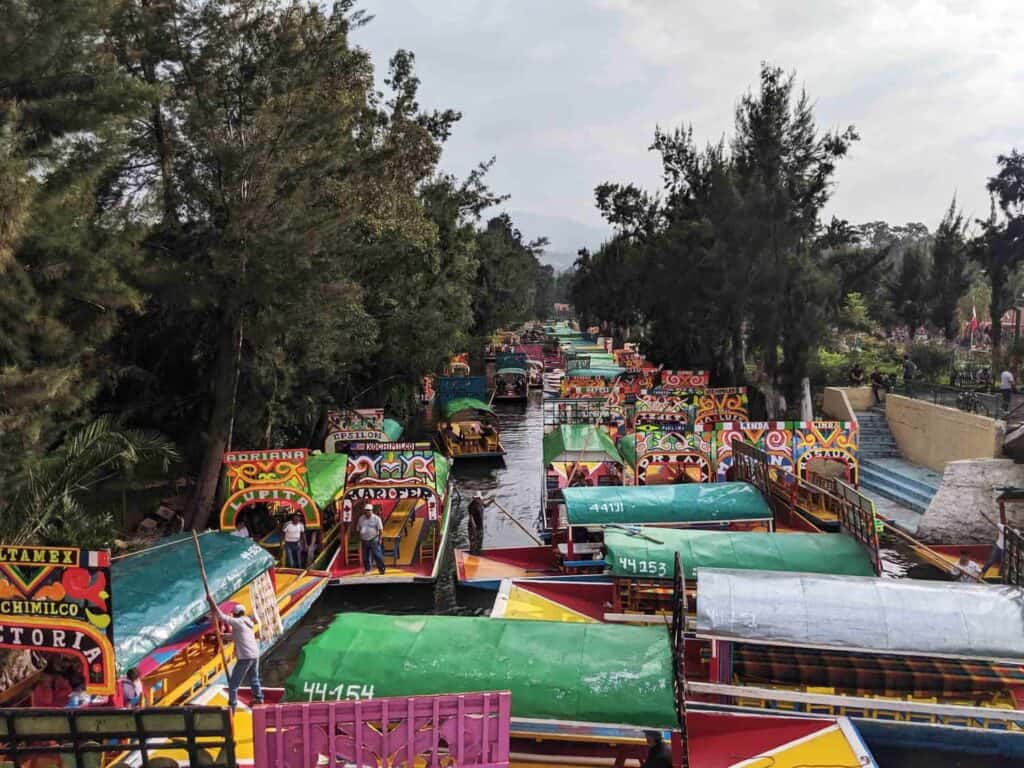 many colourful, traditional boats on a river canal in Xochimilco, Mexico