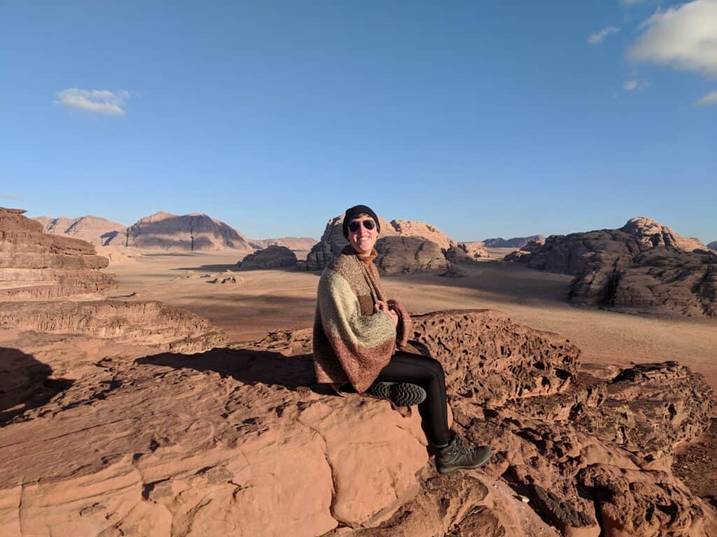 A woman sitting on a rock in Wadi Rum desert, Jordan