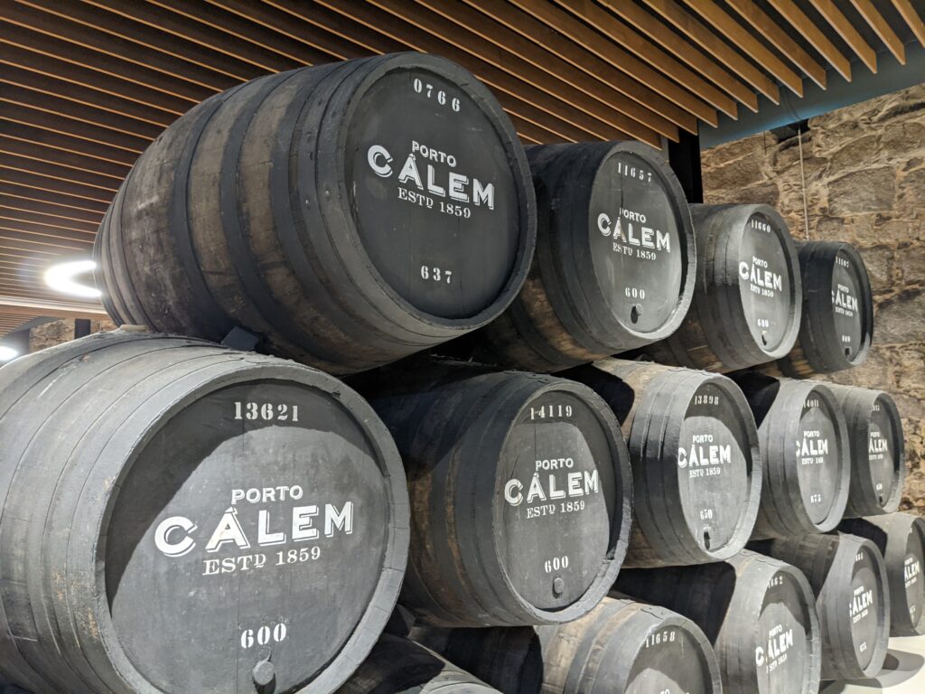 black wine barrels stacked on top of eachother at Calem Cellar in Porto.