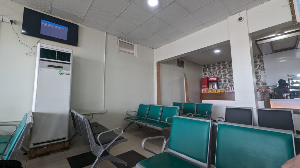 view of the chairs, television, and canteen in the waiting lounge of Zanzibar's domestic airport.