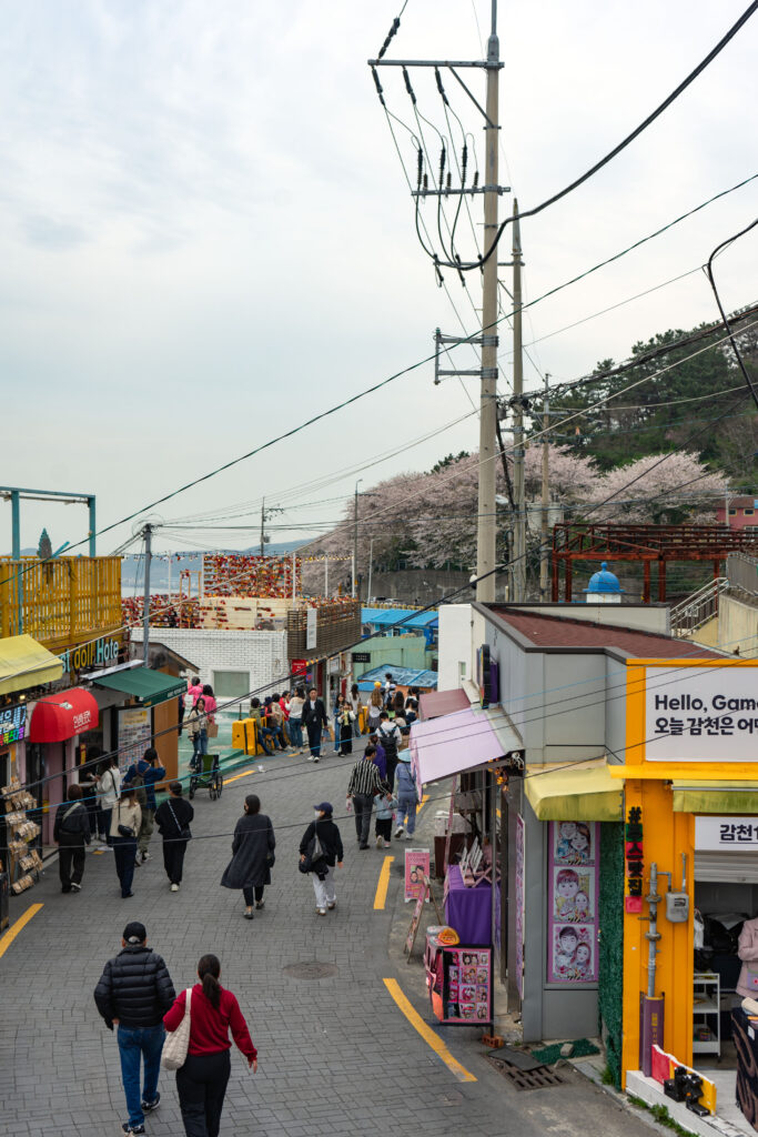 People walking down Gamnae 2-ro, the main road in Gamcheon