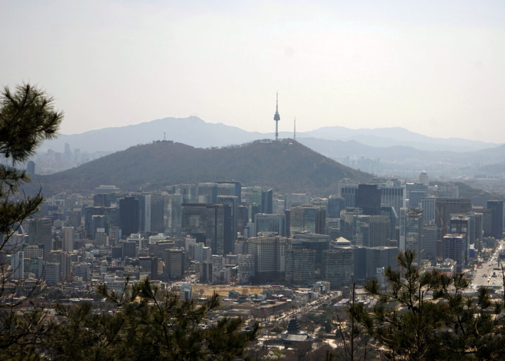 view of seoul from a mountain, with the N Seoul Tower in the distance