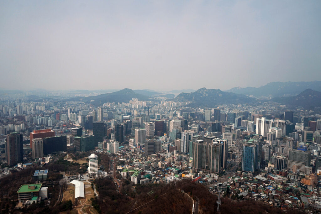 view of seoul from the n seoul tower on a gloomy day with mountains in the distance