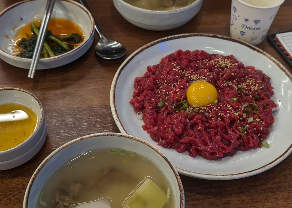 a plate of yukhoe topped with raw egg in seoul, south korea