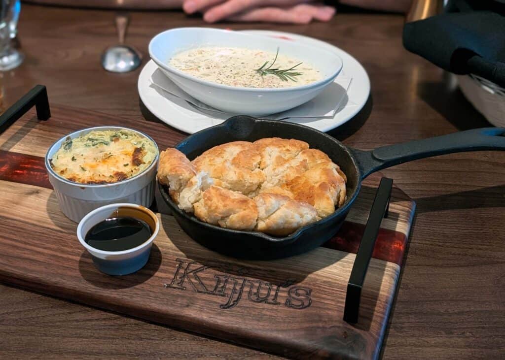 a fry pan with Mi'kmaq fry bread in it next to a bowl of seafood chowder