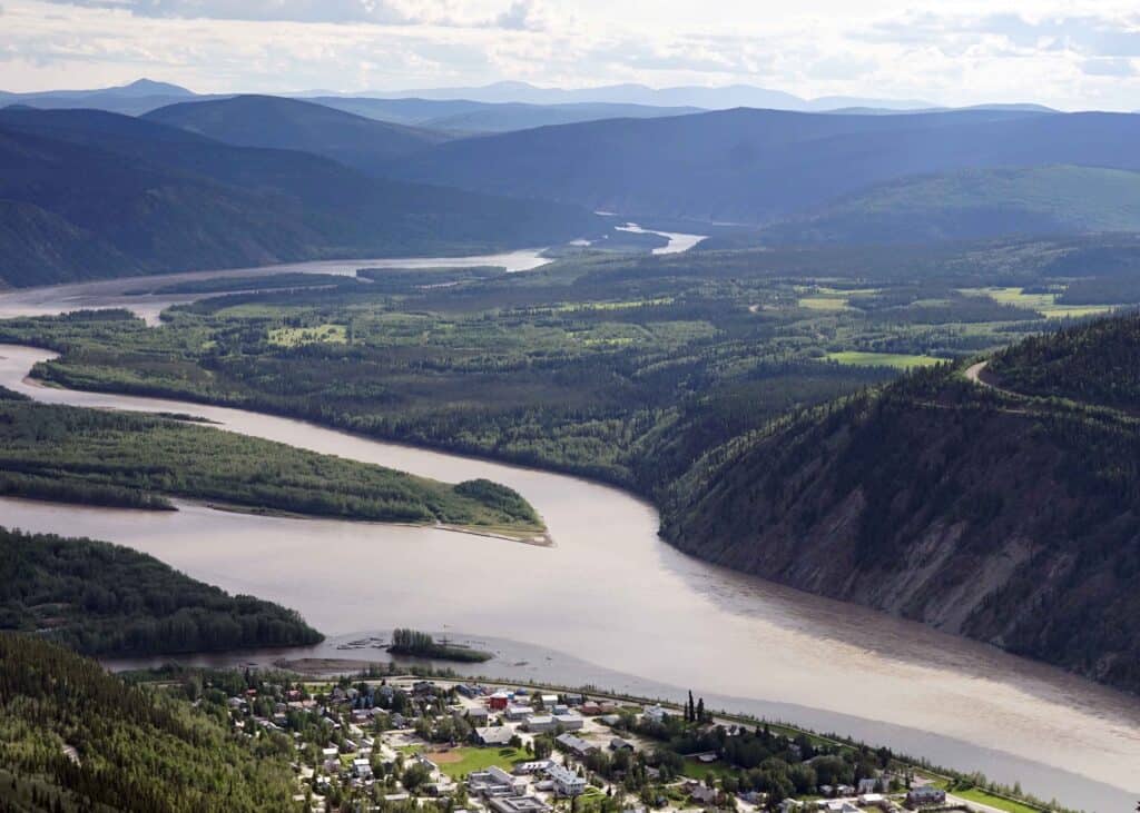 view of rolling hills, the yukon river, and part of Dawson City from the Midnight Dome viewpoint