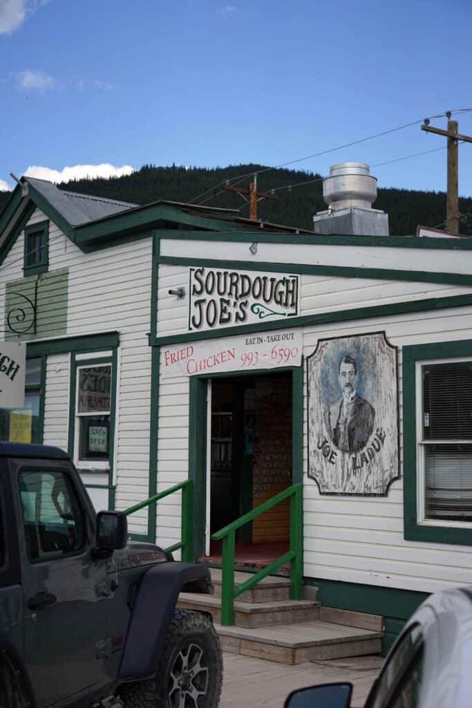 the white and green storefront of sourdough joes in dawson city yukon