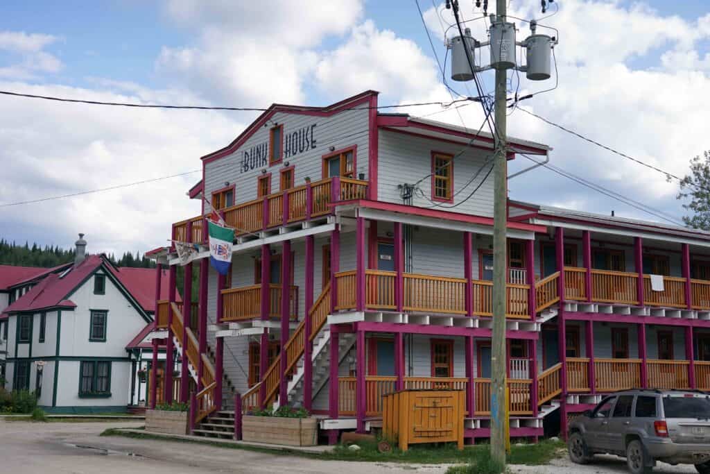 a blue and pink heritage building called "The Bunkhouse" in Dawson City
