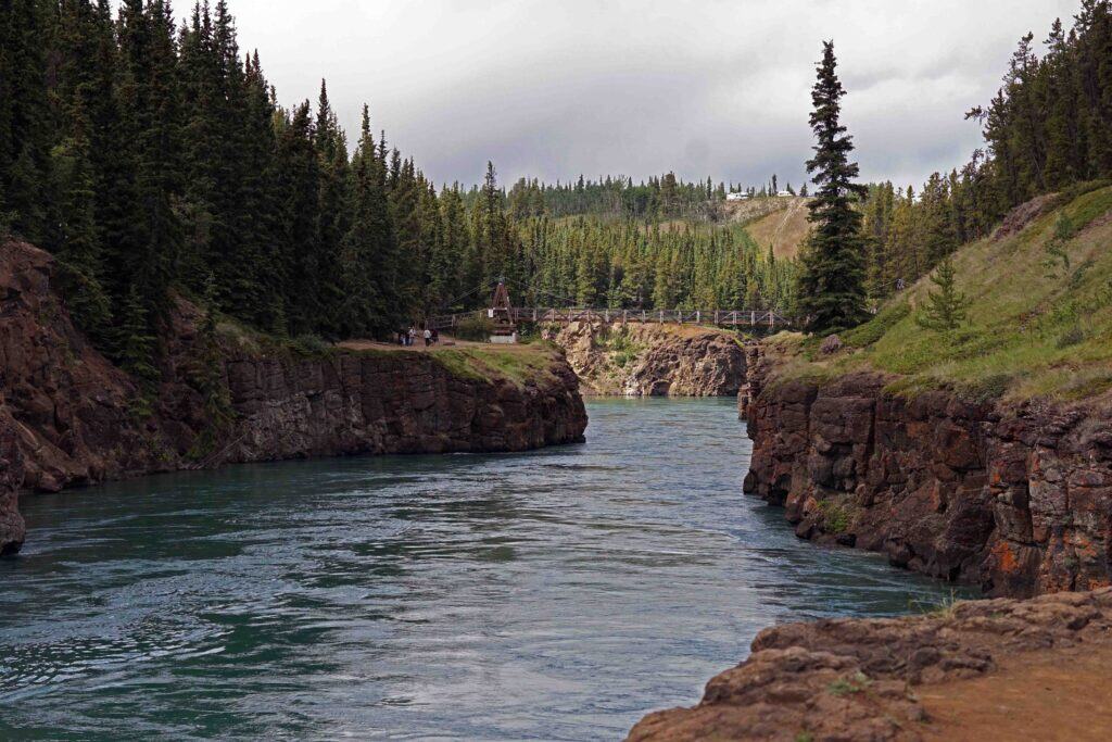 A blue river flowing through a canyon in the yukon.