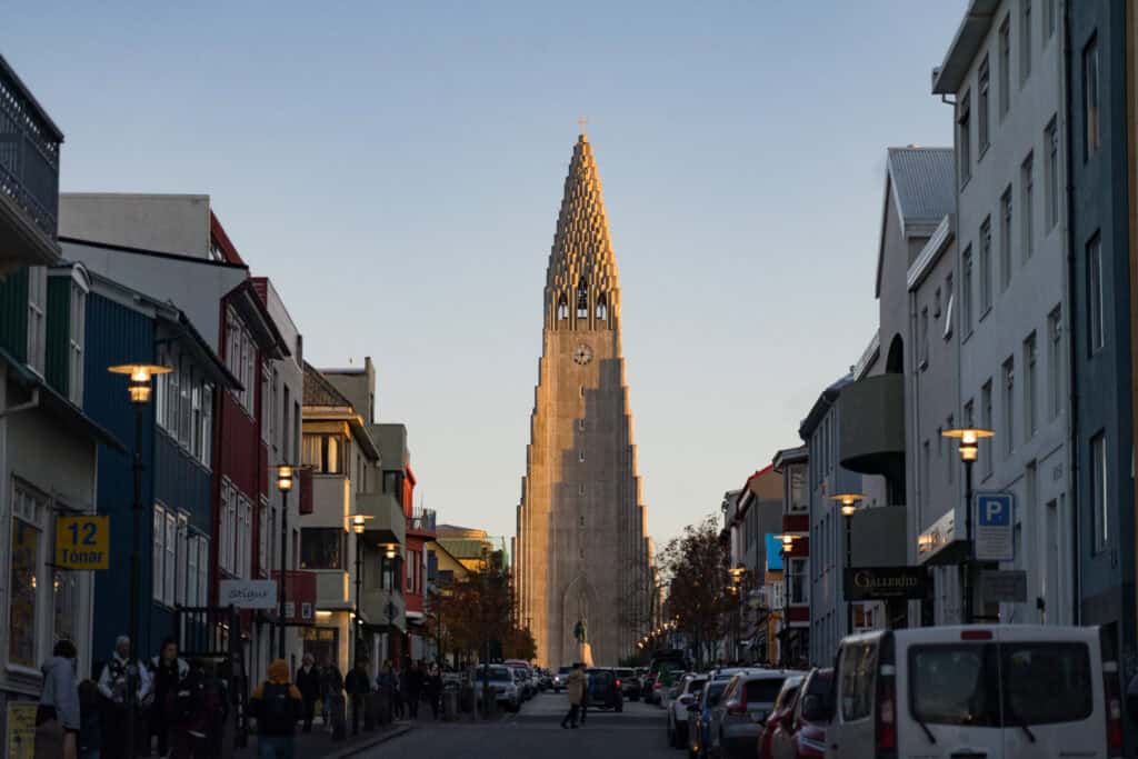 View of Hallgrímskirkja church in Reykjavik, Iceland, seen from the street with its tall tower rising above the road.