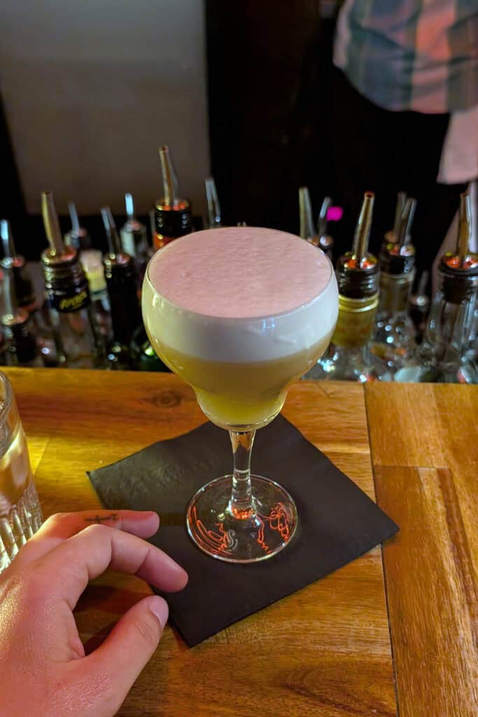 Foamy cocktail served at The 515 Bar in downtown Vancouver, a cozy winter cocktail stop near Yaletown