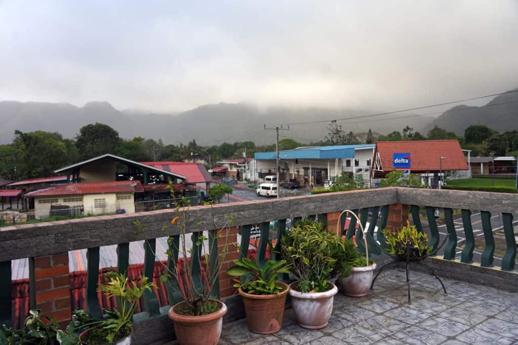 View from rooftop terrace at Residencial El Valle overlooking El Valle de Antón town with surrounding mountains and low clouds in Panama.