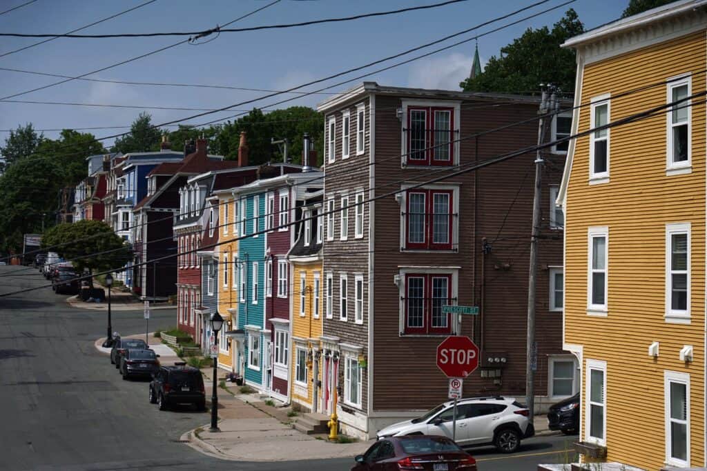 Colourful row houses lining a street in downtown St. John's, Newfoundland and Labrador, with traditional clapboard architecture and bay windows.