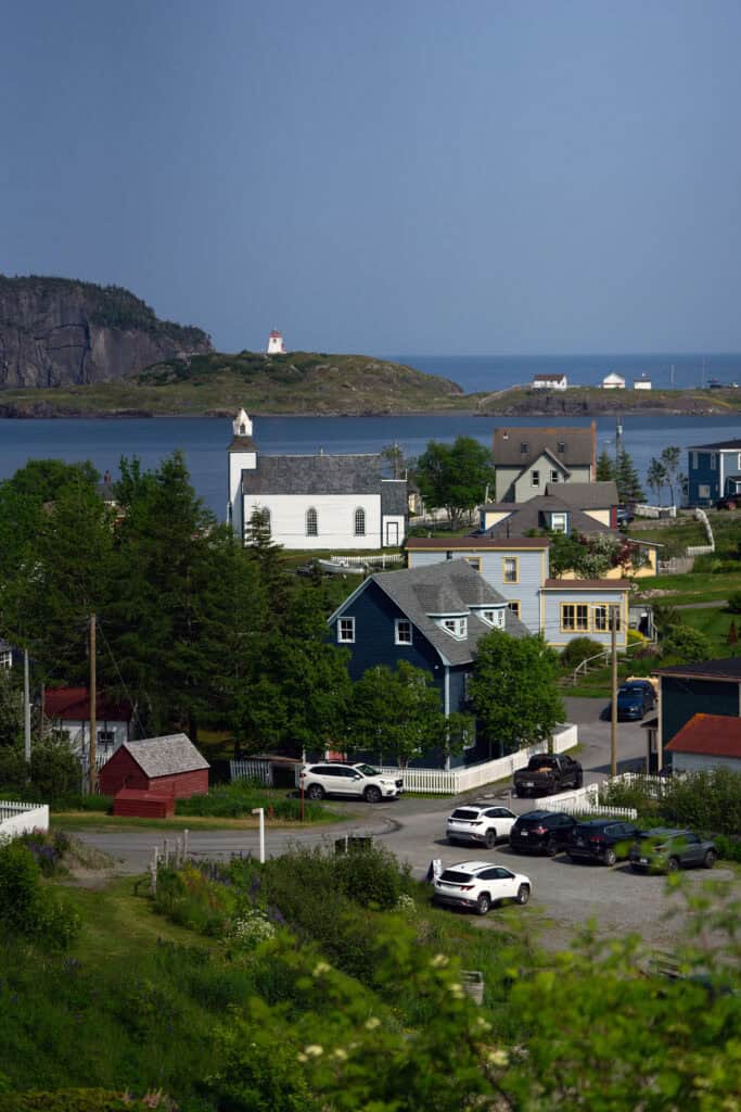 Panoramic view of Trinity, Newfoundland and Labrador, featuring St. Paul's Anglican Church overlooking the harbour and the Trinity Lighthouse in the distance.