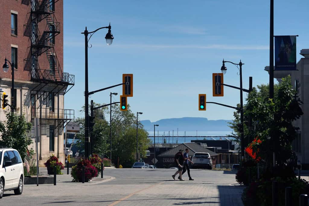 Downtown Thunder Bay street with the Sleeping Giant visible in the distance across Lake Superior.