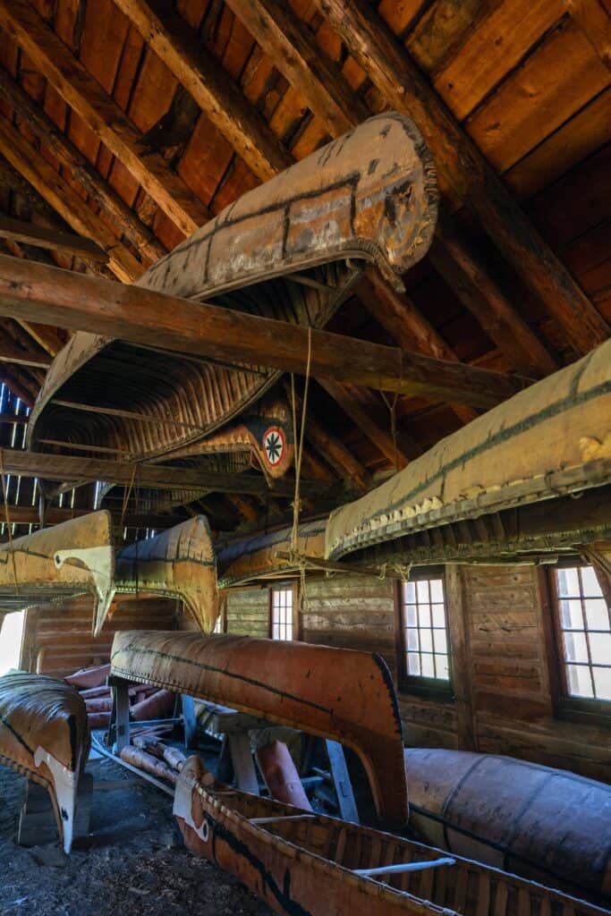 Birchbark canoes displayed inside a wooden building at Fort William Historical Park in Thunder Bay.