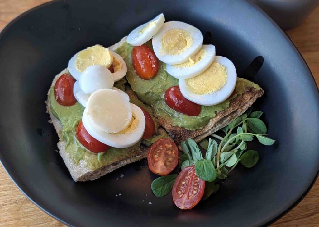 Avocado toast topped with sliced hard-boiled eggs and cherry tomatoes at gd2go in North Bay, Ontario.