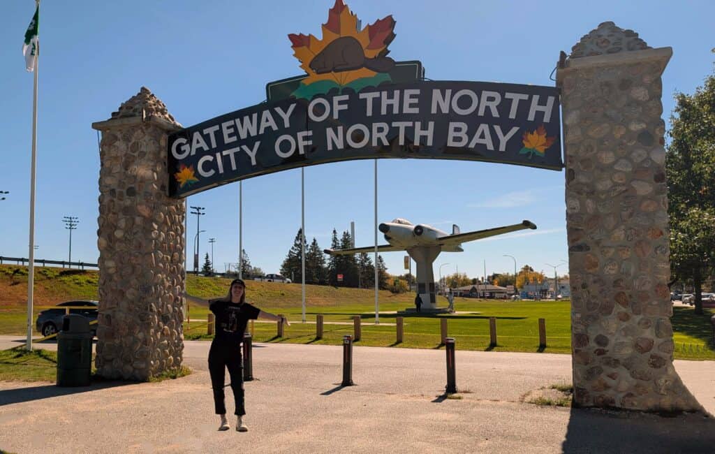 Gateway of the North sign with the CF-100 aircraft monument in the background in North Bay, Ontario.