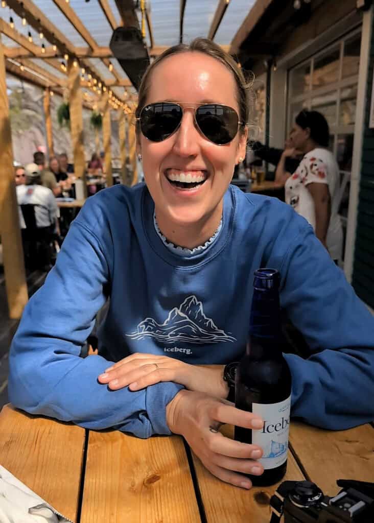 Woman drinking Quidi Vidi Iceberg beer on the patio at Quidi Vidi Brewery in St. John’s, Newfoundland and Labrador.